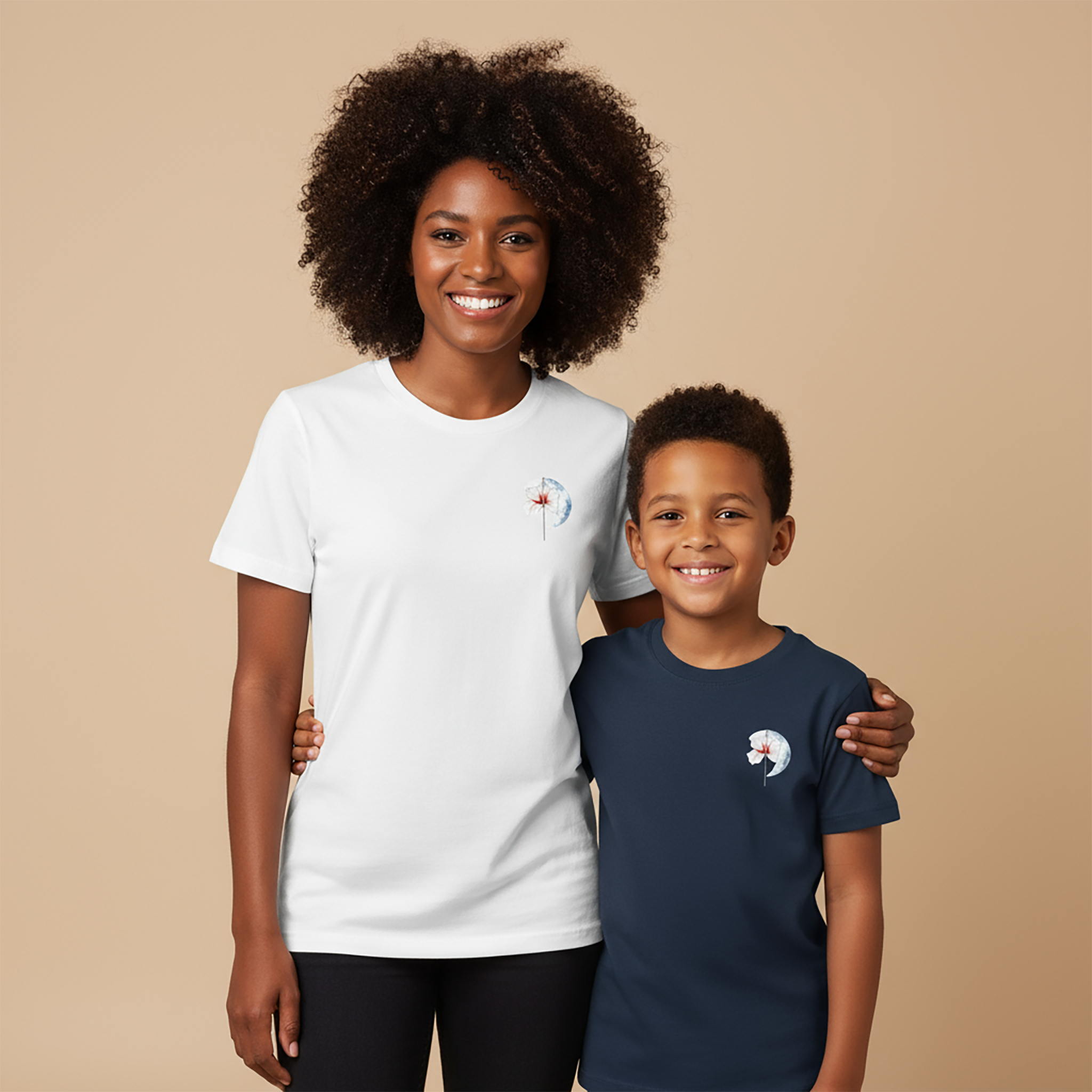 A woman and a child model the super-soft Later&Before organic cotton t-shirts. The woman wears the white tee, and the boy wears the navy blue version. Both tops feature the same subtle, artistic graphic on the left chest, making them a perfect staple for all ages.