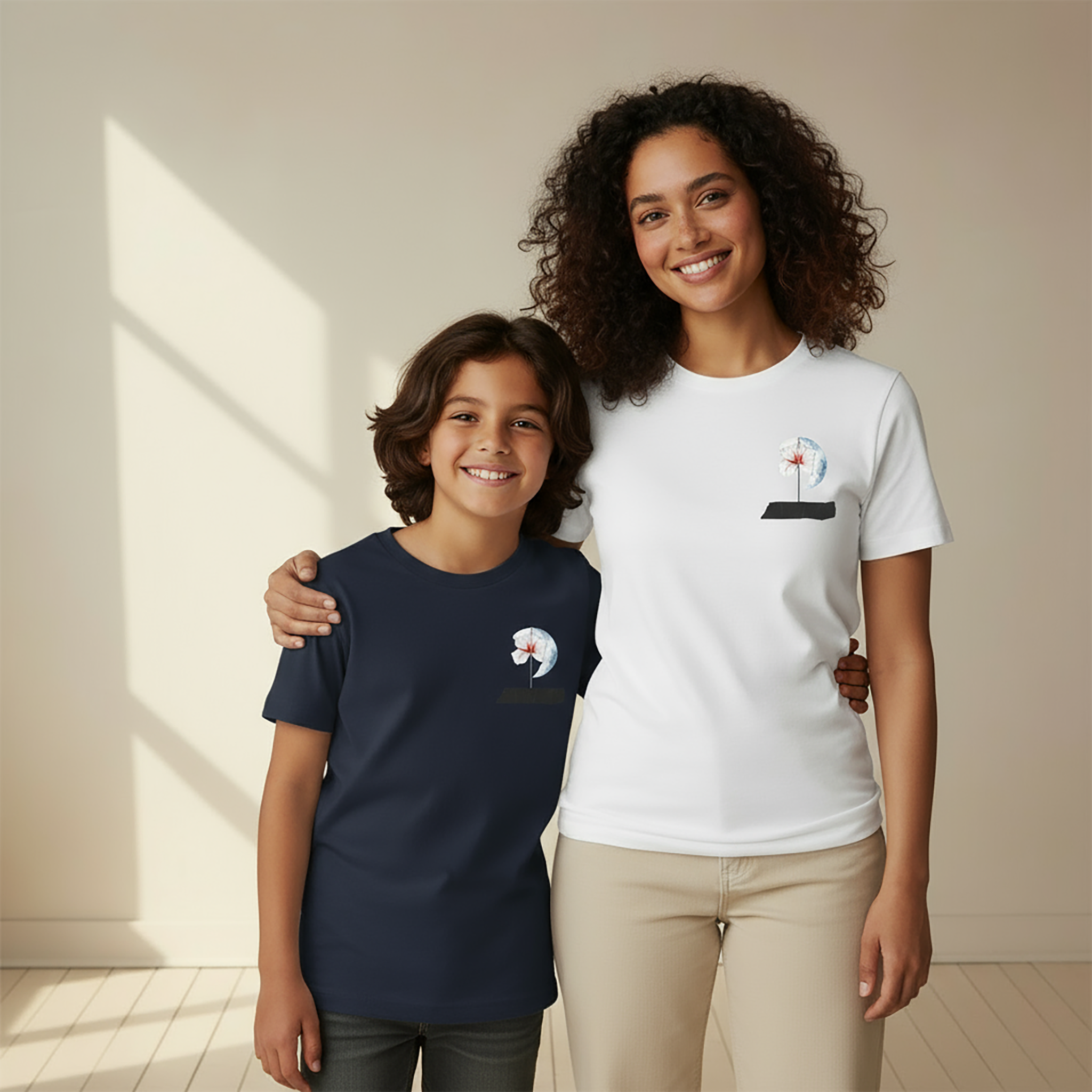 A woman wearing a white Later&Before 100% cotton t-shirt and a young boy wearing the same minimalist design on a navy blue t-shirt, smiling.